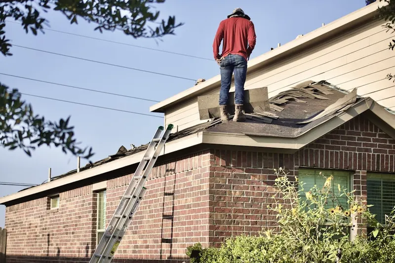 Professional roofer working on a residential roof in Otis Orchards-East Farms